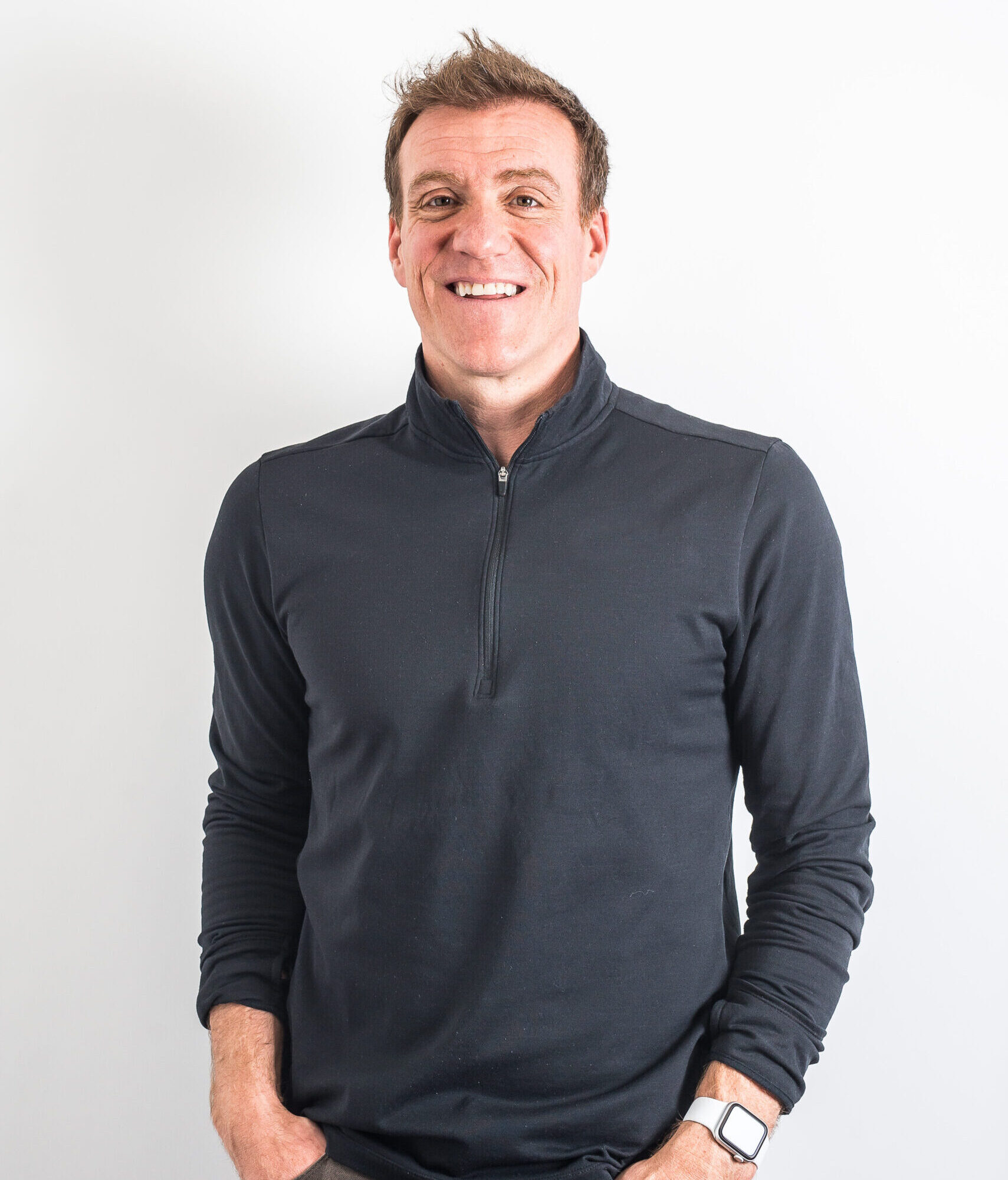 Andy Ramage, world class coach and trainer wears a black shirt against a white background, he's smiling at the camera. This is the person who leads the coaching course.